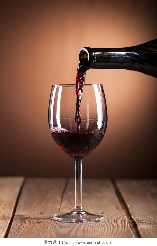 往桌上的玻璃杯里倒葡萄酒瓶灌装葡萄酒杯